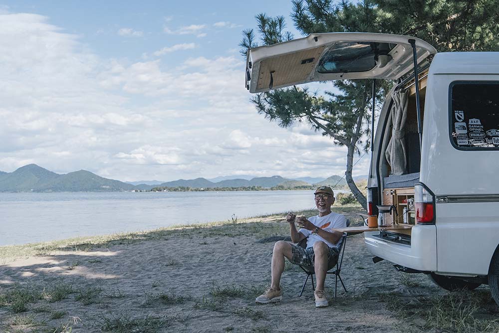 クルマ後部のテーブルでお茶をするウィンピーさん