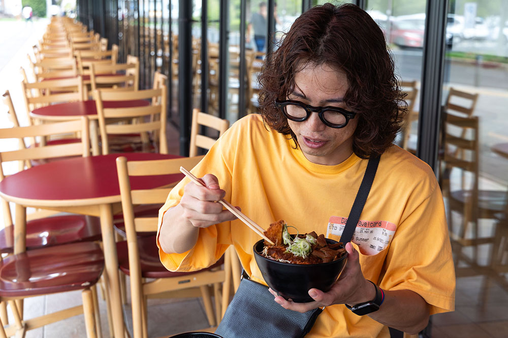 どてかつ丼スープセットを食べる男性