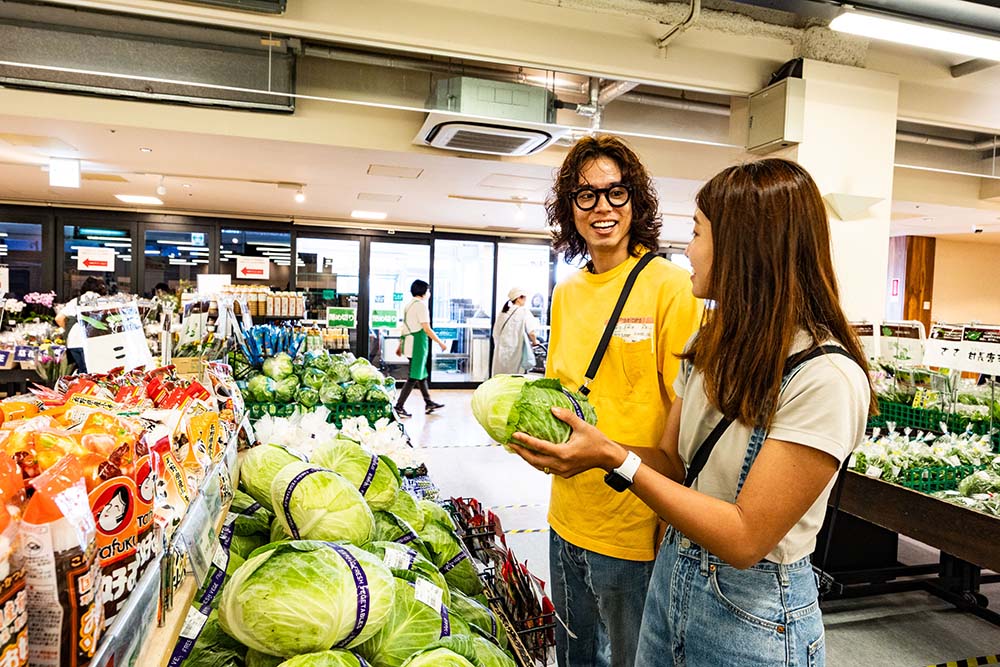 キャベツを持って話す男女
