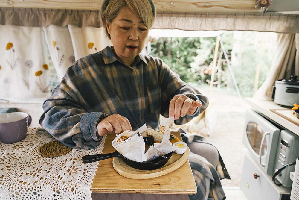 電子レンジで温めた即席ハンバーグの包みを開くyokkoさん