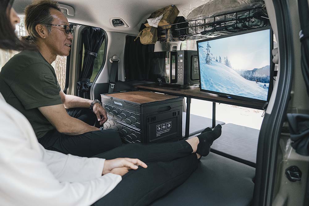 二人でテレビを見ながら車内で過ごしている様子