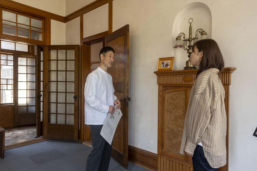 館内で館長のガイドを聞く磯野さん