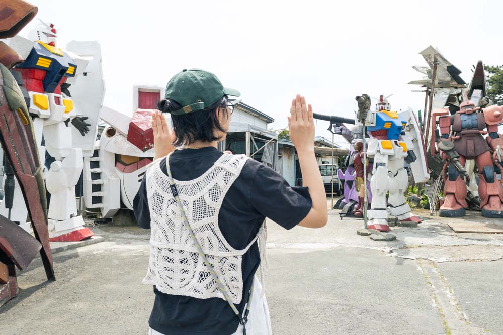ビームライフルを構えるガンダム像の前に投降する栗本さん