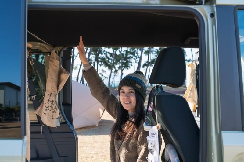 Hondaの軽自動車N-VANに座るもりこさん。室内の高さがあることを説明している