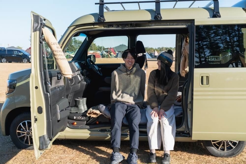 Hondaの軽自動車N-VANのドアを開けて並んで座る野外のもりこさん夫婦