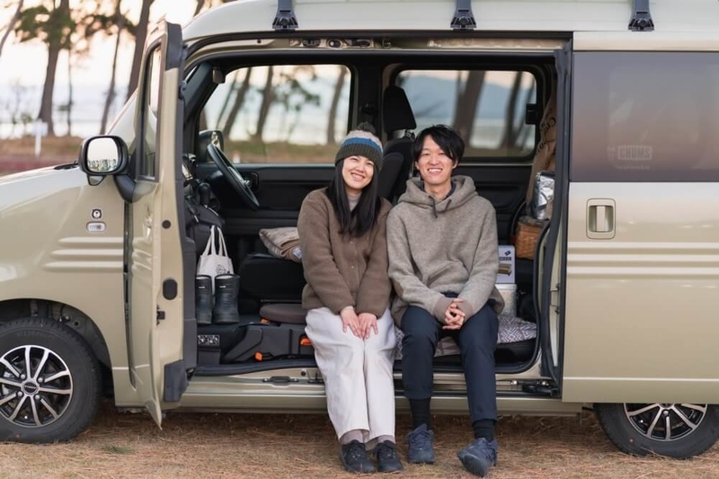 Hondaの軽自動車N-VANのドアを開けて座る野外のもりこさん夫婦