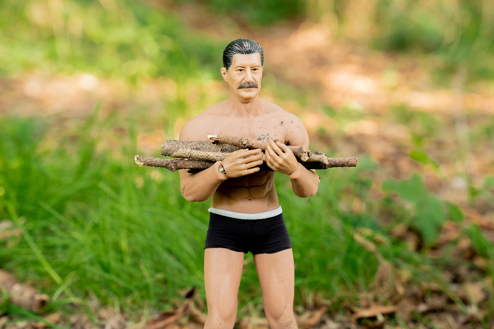 焚き火用の薪を手に持つヨシダさん