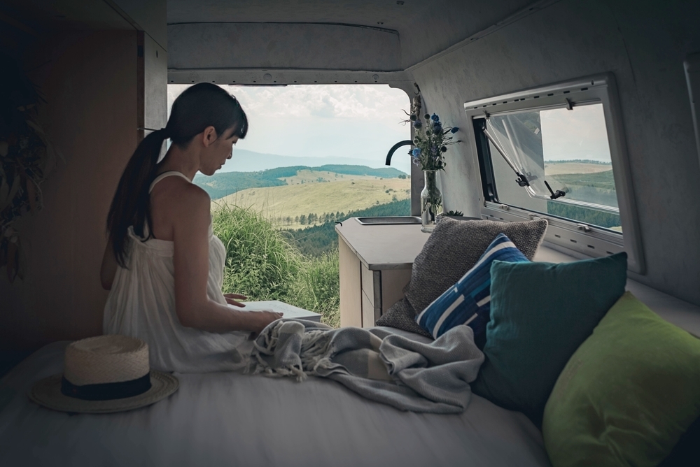 車中泊できるようにカスタムしたベンツの車内で、ベッドに座る奥はる奈さん