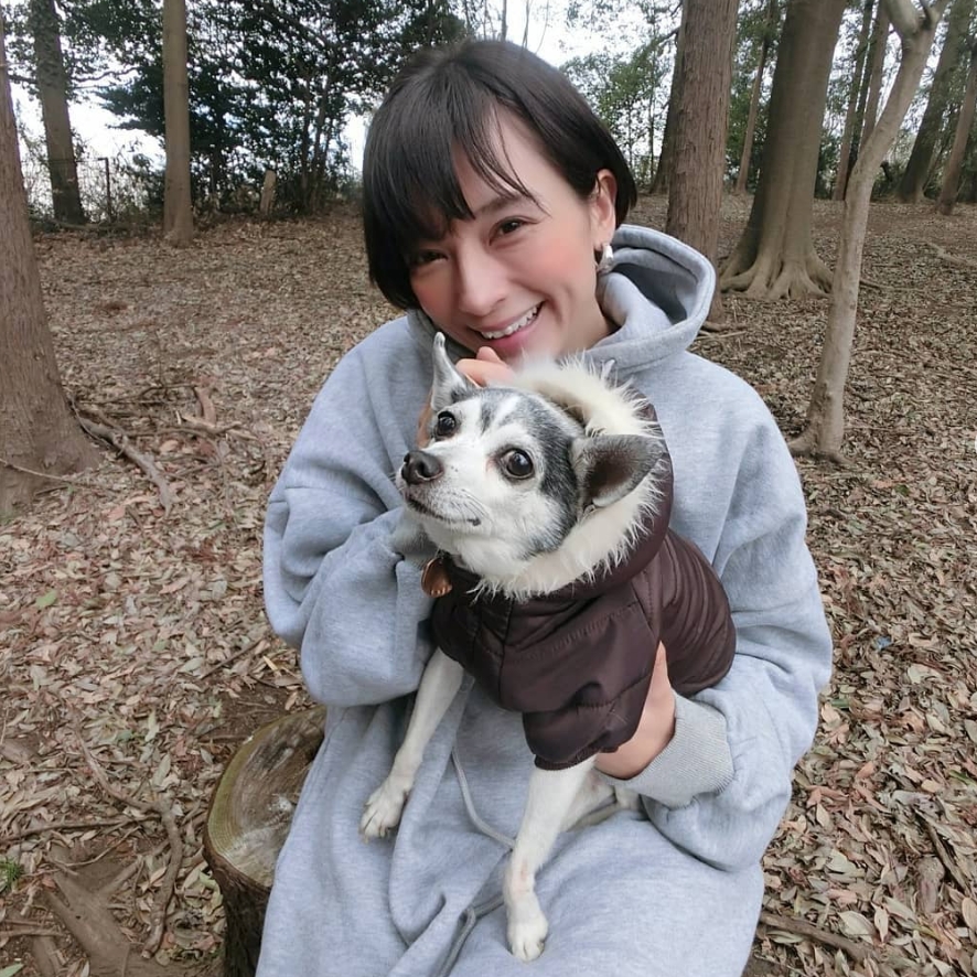 ダウンを着た犬を抱く芳美さん