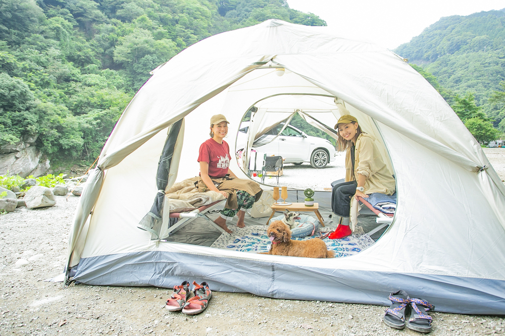 テントの中でくつろぐ女子キャンパーとペット