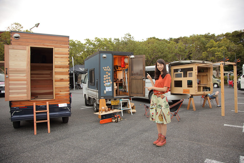 屋外会場に立ち並ぶモバイルハウスの前でポーズをとる森さん