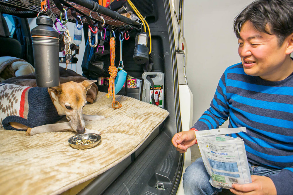 ペットの犬におやつをあげる男性