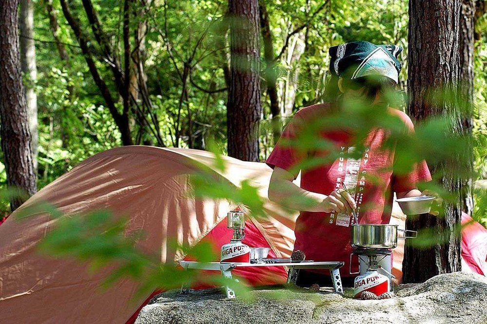 車中泊のプロがおすすめ便利グッズ、車中泊の必需品、装備と道具を紹介。オートキャンプ場で、食事を作る女性