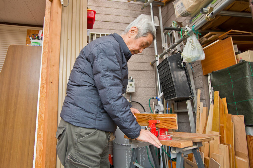 作業小屋で板を加工する男性