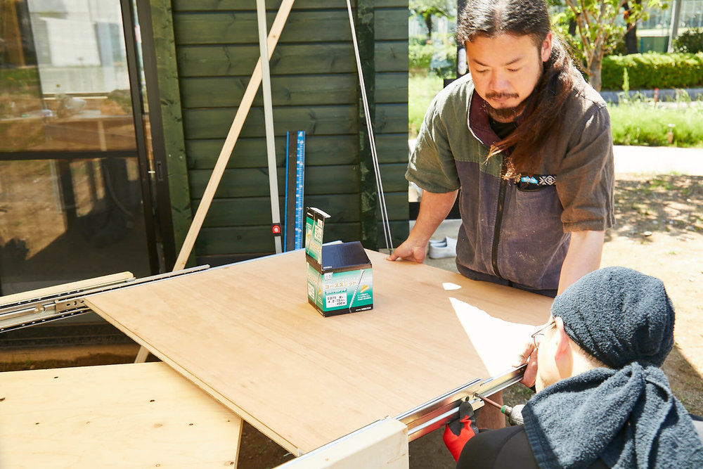 車中泊DIYカスタムでテーブルとベッドを作る。スライドレールの内側に天板をはめているところ