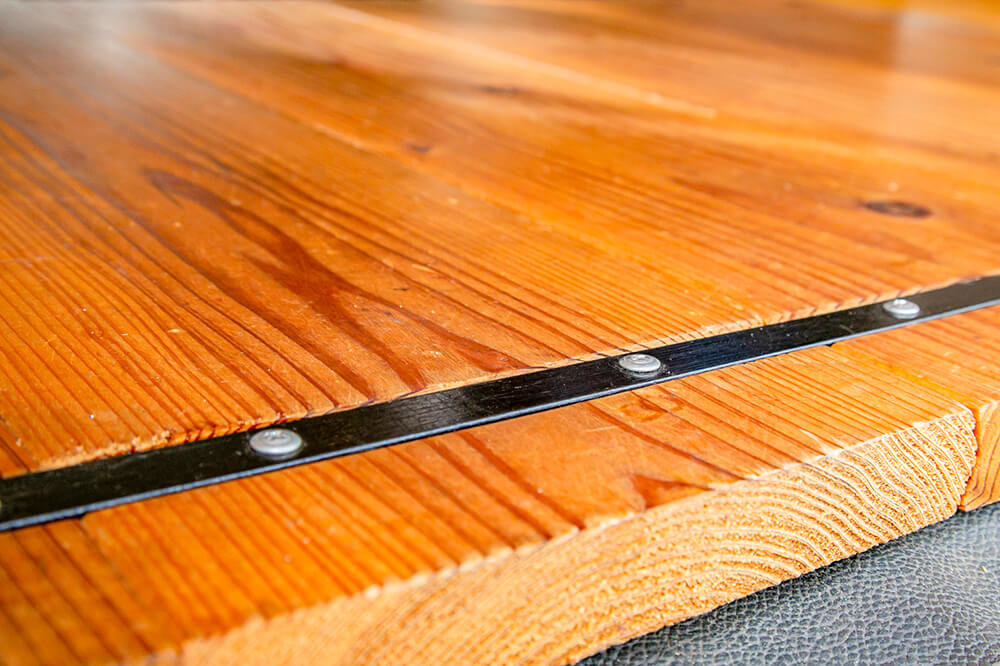 杉の無垢材のアップ。板の表面に溝を作り、金具で連結している