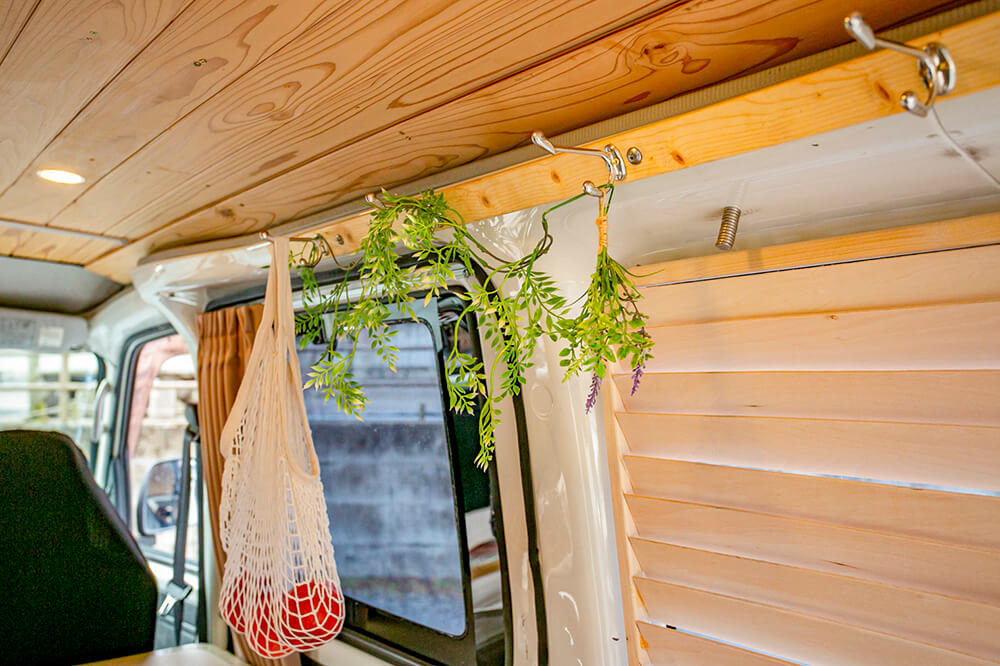 壁の天井に近いところに板を貼ってフックをつけている。フックには、リンゴが入ったネットバッグを吊るしたり、フェイクグリーンを飾ったりしている