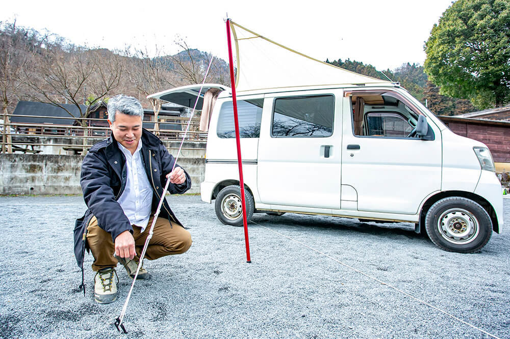 カーサイドタープを設置している渡辺さん