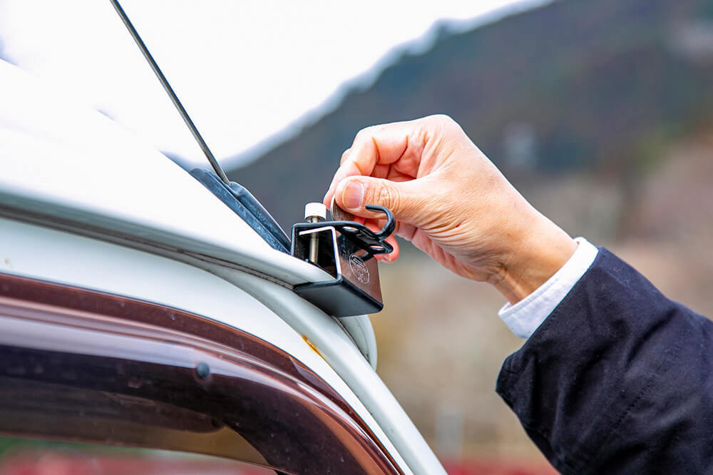 車両のレインガーター（雨どい）にキャプテンスタッグのテント・タープ用カージョイントを取り付けているところ