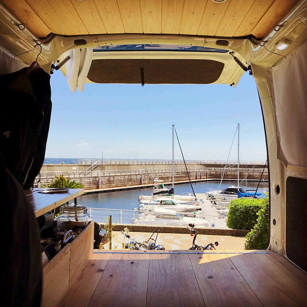 静岡県伊東市の道の駅「伊東マリンタウン」にて。バックドアを開けて、外には海とボートが見える