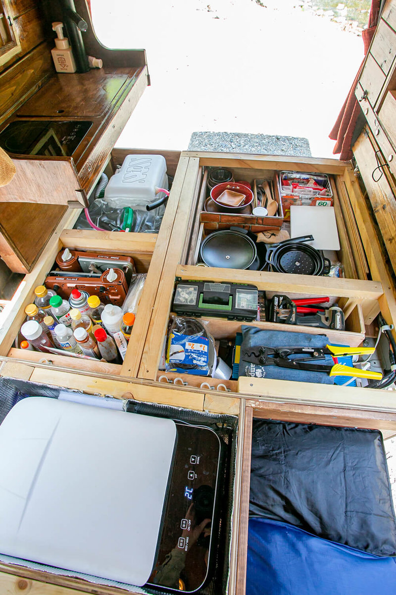車内の床の収納スペースに調味料や食器、冷蔵庫、工具などが入っている