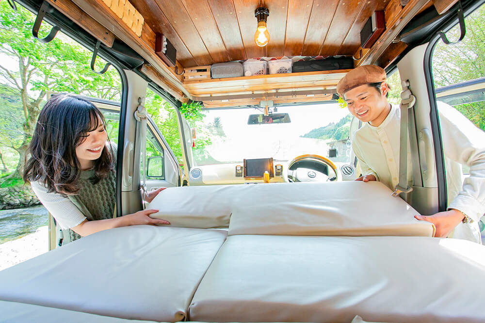 シートを倒して車内の床にマットレスを敷いているところ
