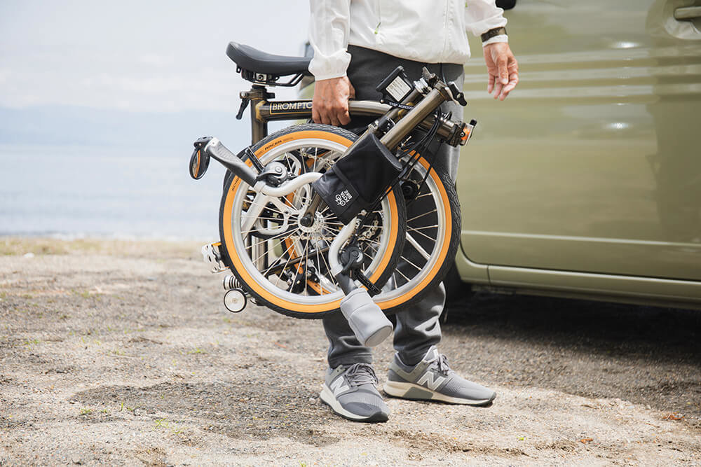 折り畳み自転車（ブロンプトン）を持つ中村さん