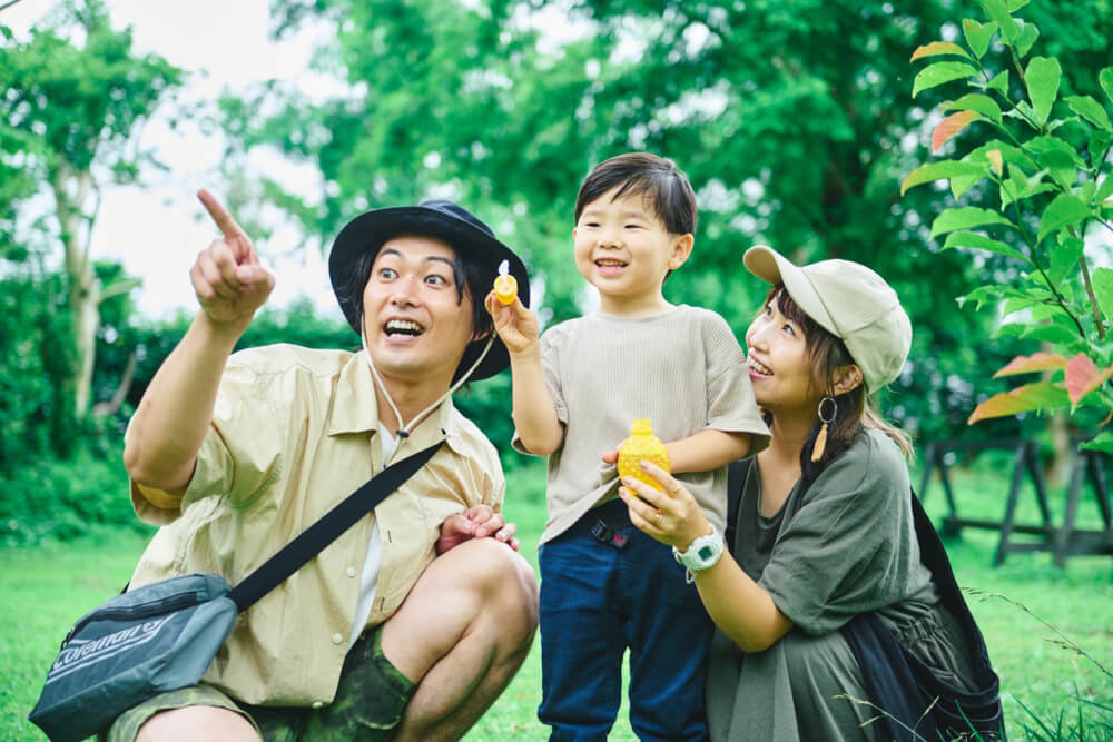 キャンプ場で自然とふれあったり、ボール遊びをしたりして家族団らんしているシーン
