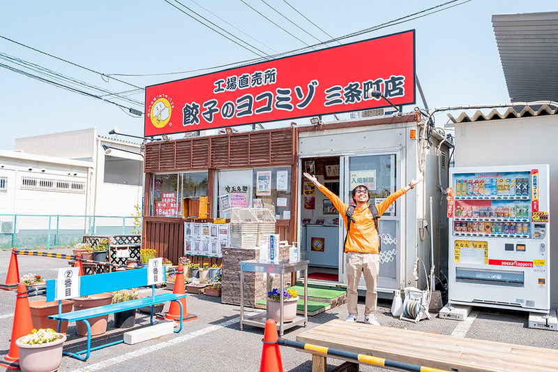 餃子のヨコミゾの前に立つ地主さんの写真