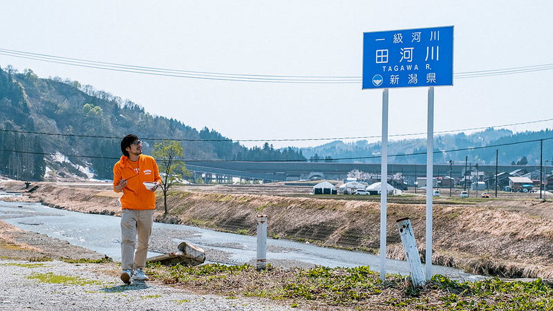 田川と書かれた看板を見る地主さんの写真