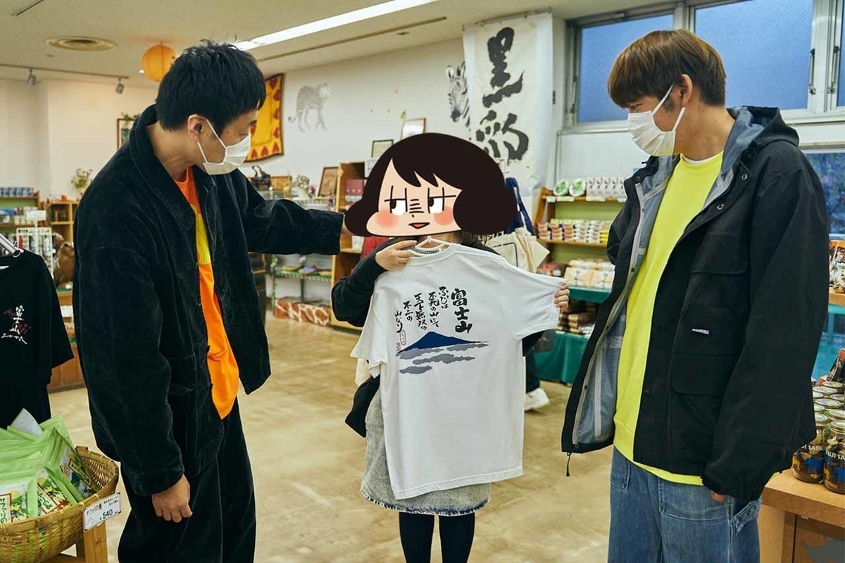 五明さんが見つけたTシャツを山本さほさんにあてがう写真