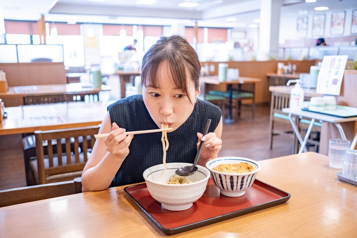 冷やしたぬきうどんをほおばるライター山口真央さん