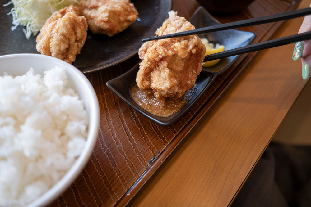 から好しの特製ソースに唐揚げをつける山口真央