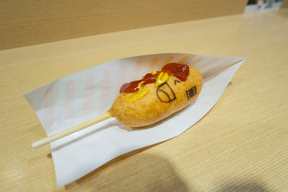 アメリカンドッ君にケチャップとからしをつける