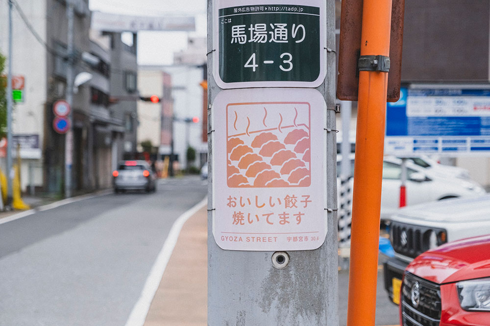 餃子通りの電柱には「おいしい餃子焼いてます」の看板も