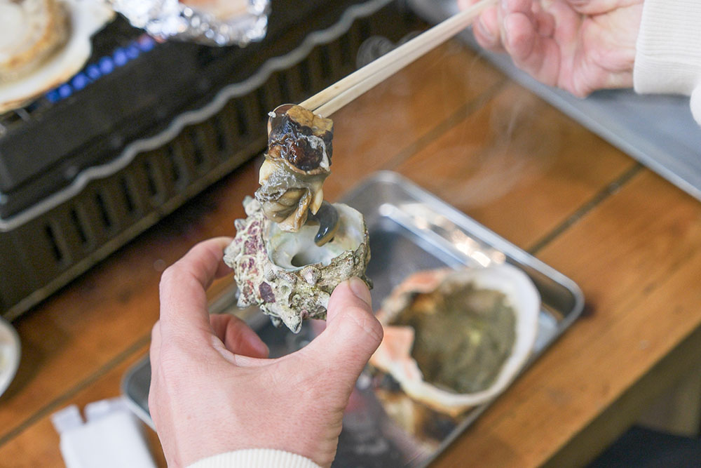 焼き上がったサザエを食べようとする杉本清隆さん