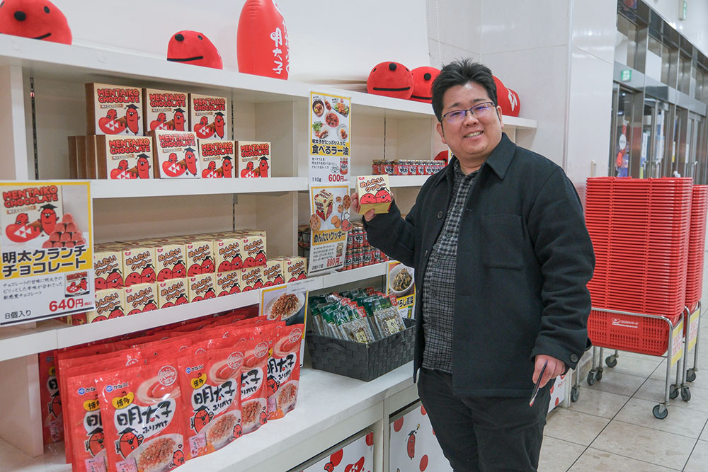 めんたいパークのお土産「明太クランチチョコレート」を手に持つ少年Bさん