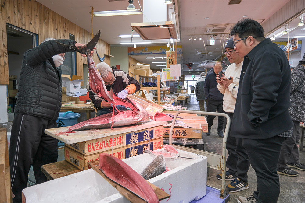 2人がかりでマグロを解体しているところを見学している少年Bさん