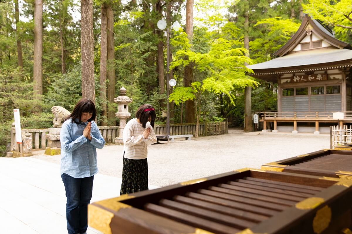 宝登山神社の本殿で金運アップを祈願する女性たち