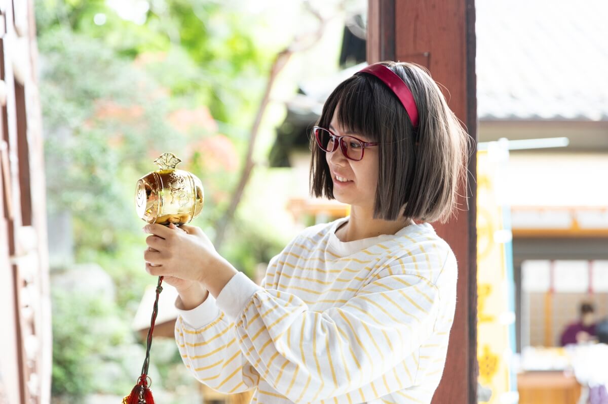 48_金運アップを祈願して打ち出の小槌を振る女性