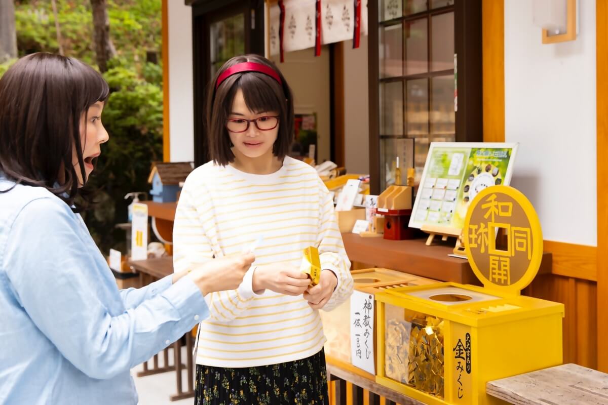 聖神社で「大大吉」のおみくじを引いて驚く女性