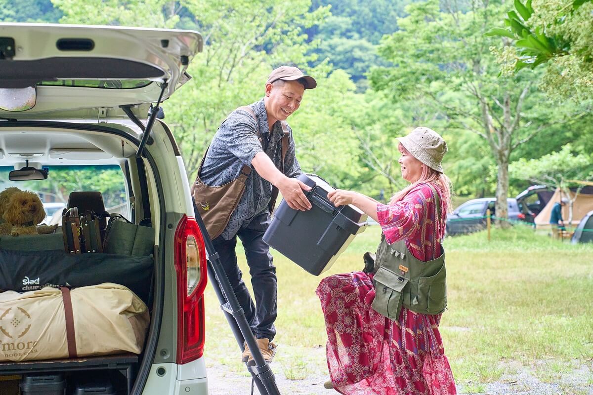 脚立に乗っているタローさんに、はるぴんさんがコンテナボックスを渡しているところ