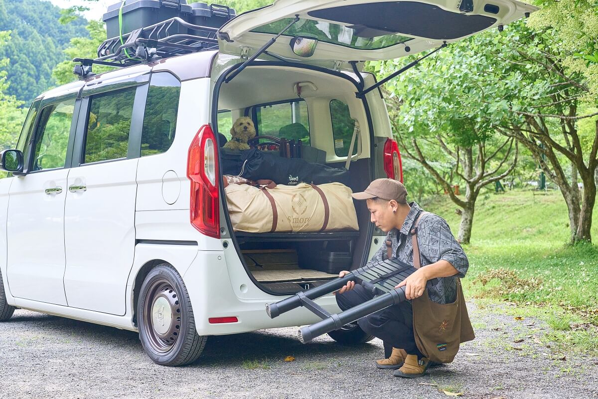 タローさんが脚立をコンパクトにまとめて、ベッドの下の収納スペースに入れようとしているところ
