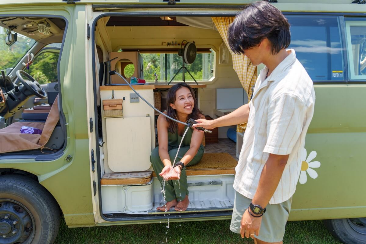 【ちゃんじろー夫婦】の自作キャンピングカー、伸縮式ホースの水道で手を洗っているところ