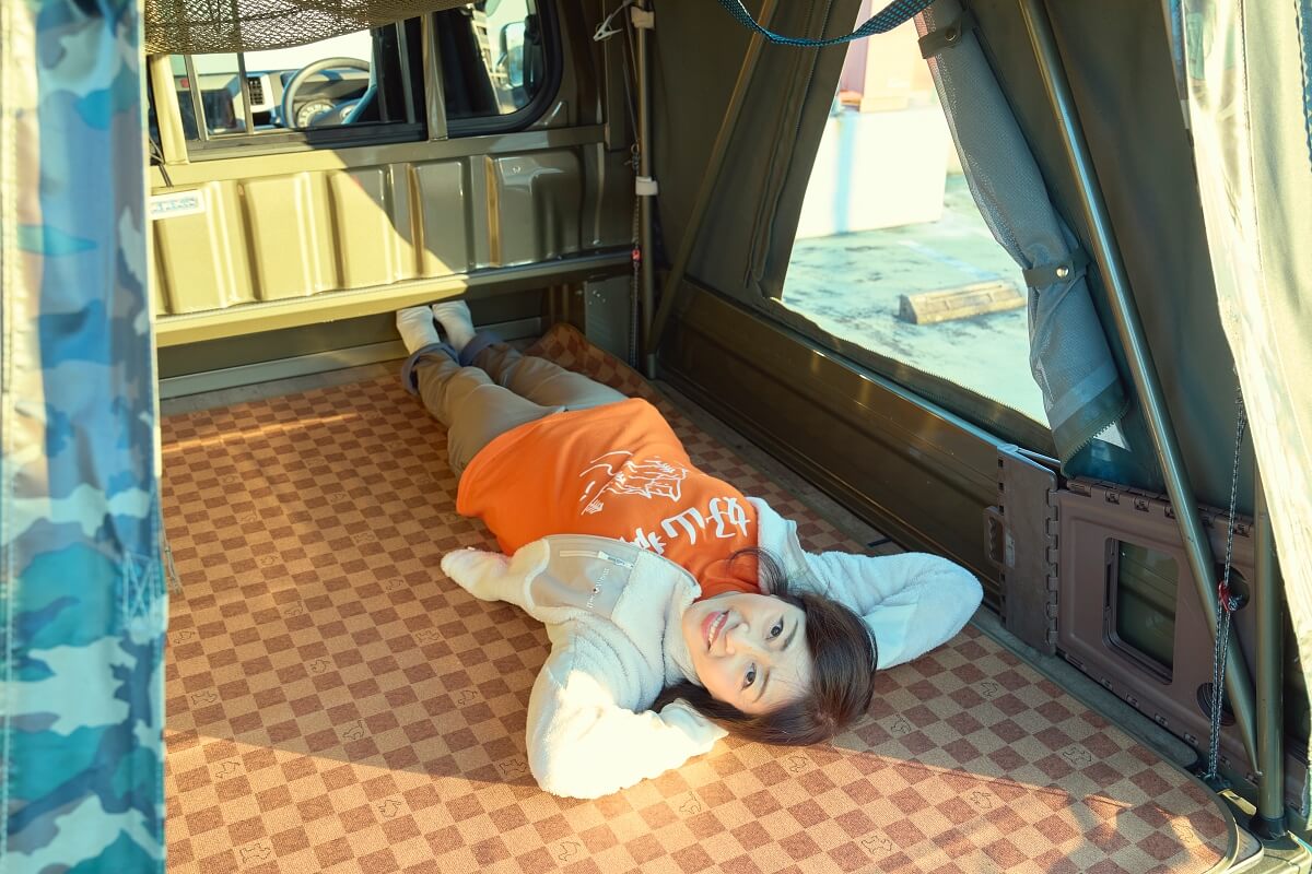 バグトラの荷台に寝転んでいる松本明子さん