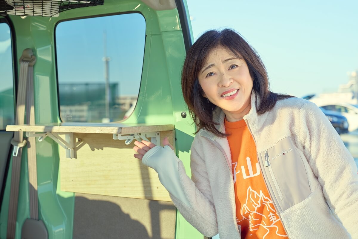 イージーライダーの荷室にDIYで取り付けたテーブルについて説明する松本明子さん