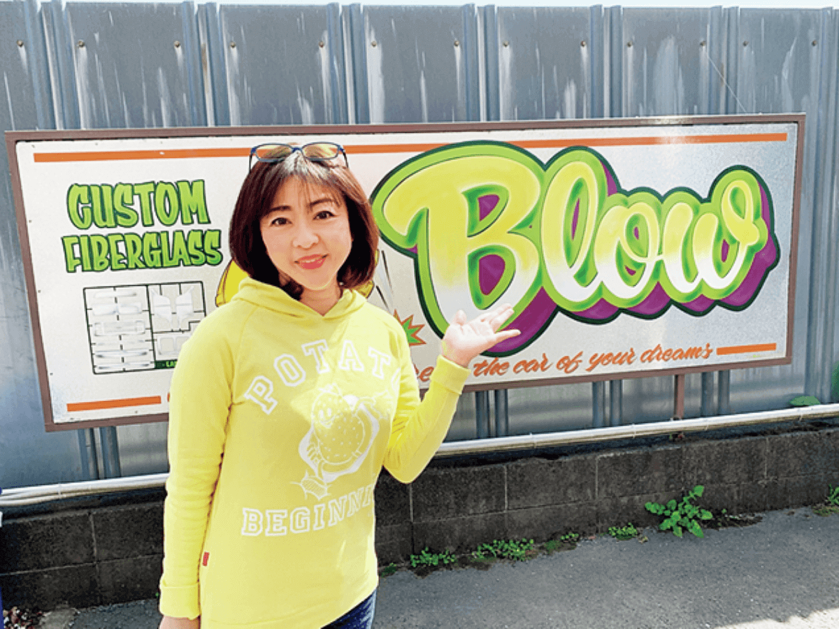 ブローの看板の前に立つ松本明子さん