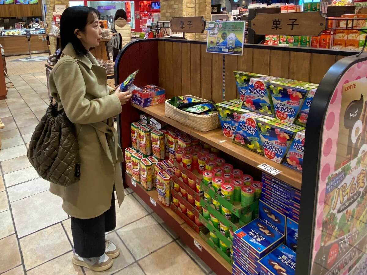 談合坂SAで富士山のお菓子を手に取る辛酸なめ子さん