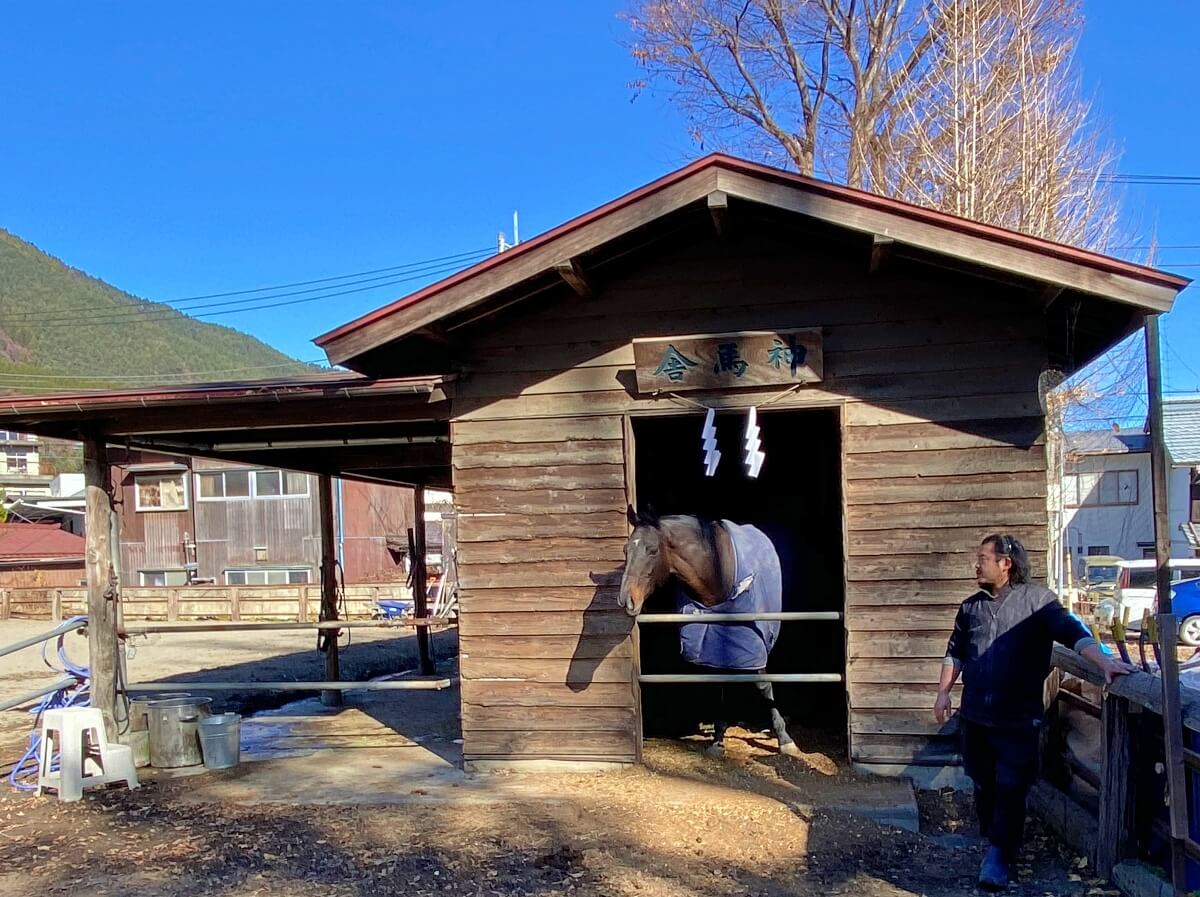 小室浅間神社の神馬舎にて。神馬のサラブレッドと世話係の男性