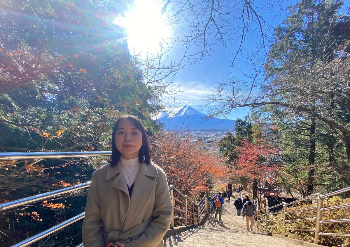  小室浅間神社にて。富士山を背後に立つ辛酸なめ子さん